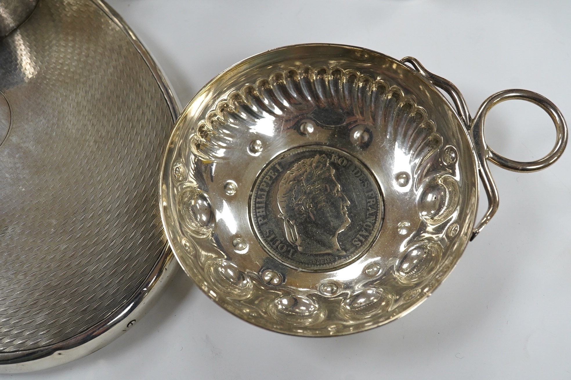 Small silver including a napkin ring, hand mirror and two mounted glass toilet jars, together with three Indian white metal condiments and a French white metal wine taster. Condition - poor to fair